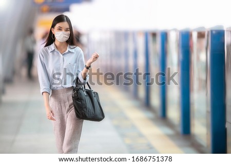 Asia working woman going to work and  
wearing hygienic mask prevent corona virus and going to work at
Sky train station Royalty-Free Stock Photo #1686751378
