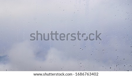 water drops on a window in front of grey sky