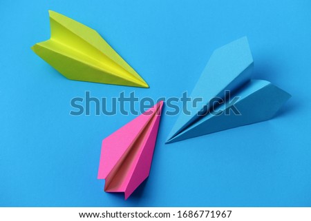 Paper airplanes, adventure symbol, on blue background