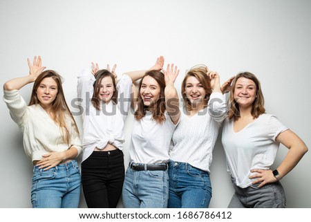 Five girlfriends in similar clothes pose with different emotions in the studio Royalty-Free Stock Photo #1686786412