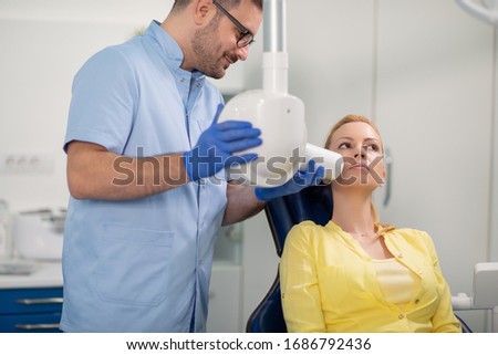 Dentist prepare to make tooth x-ray image for patient in dental clinic.People,medicine, stomatology and healthcare concept.