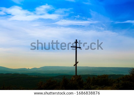 Black religion symbol silhouette Jesus Christ wooden cross on a background with colorful mountain sunset, Easter concept