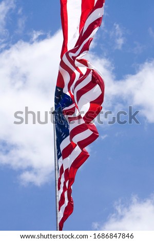 Waving American US Flag in Blue Sky with Clouds