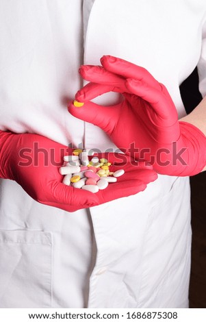 hospital nurse in red gloves holding tablets on Covid-19