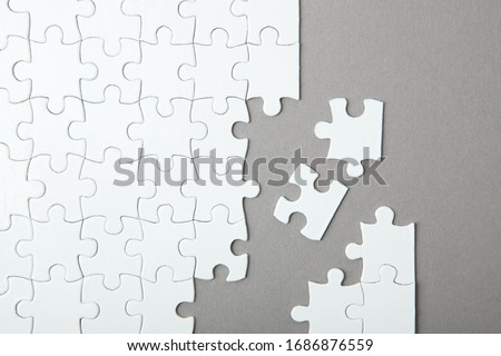 White puzzle on a colored background top view.
