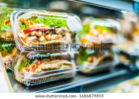 Chilli chicken with pita, pre-packaged sandwiches displayed in a commercial refrigerator