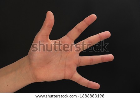 the palm of a teenager's hand on a black background. body parts