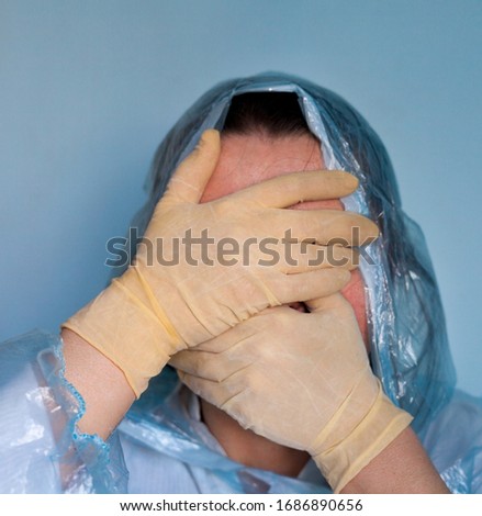 Woman in a protective suit closing her face. Distressed woman. Coronavirus (Covid-19) disease outbreak.  Royalty-Free Stock Photo #1686890656