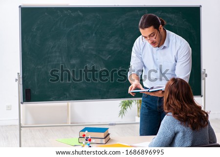 Young female student and male teacher in the classroom Royalty-Free Stock Photo #1686896995