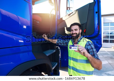 Truck driver candidate showing CDL driving license for transportation vehicles. Successfully passed training driving exam. Royalty-Free Stock Photo #1686913678