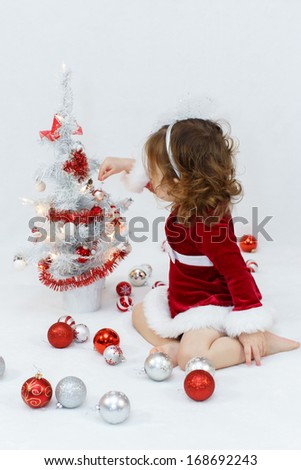 Baby Girl dressing up christmas tree