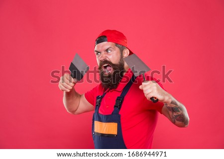 Successful renovation. Bearded man worker with plastering tools. Plasterer hipster builder in cap red background. Interior designer. Professional plasterer. Skillful plasterer. Repair success.