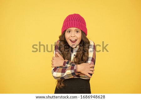 She is cold. Unhappy little child feel cold yellow background. Small girl shiver in cold weather headwear. Crispy autumn or winter season. Chilly and cold. Coldness. Royalty-Free Stock Photo #1686948628
