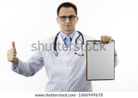Handsome male senior age doctor in white medical lab coat and stethoscope showing like sign with thumb up, holding clipboard with blank paper with copy space for text. Approved by doctors concept