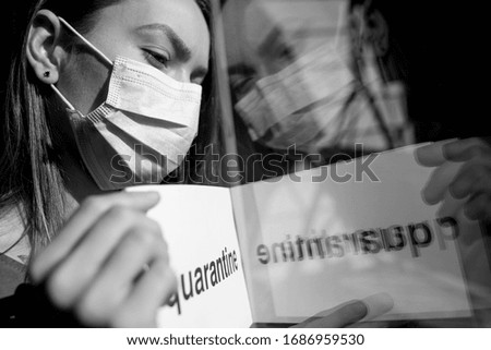 The girl outside the window holds a quarantine sign. Mass epidemic, quarantine. Media and online publications. Crown virus and self-isolation.