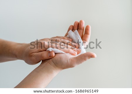 Man wipes his hands with a antibacterial alcohol wet wipe. Coronavirus and rotavirus prevention Royalty-Free Stock Photo #1686965149