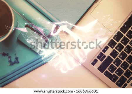 Handshake drawing over computer on the desktop background. Top view. Double exposure. Partnership concept.