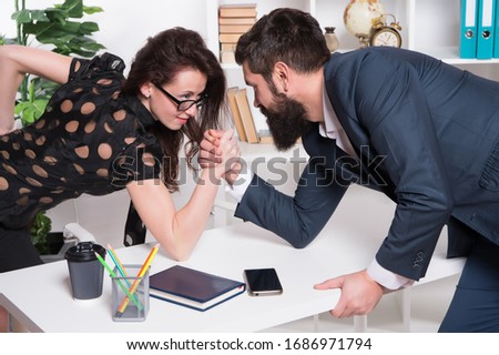 Gender equality. Career in business. Worthy rival. Underestimate forces. Equal rights. Feminism concept. Business competition. Business leadership. Man and woman tense faces compete armwrestling.