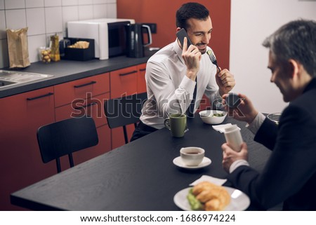 Mature office worker trying sugar substitute during coffee break in the office stock photo. Business concept