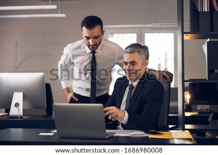 Smiling office workers talking to each other indoors stock photo. Business concept