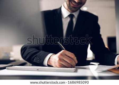 Close up of man in suit making notes during negotiations stock photo. Business concept