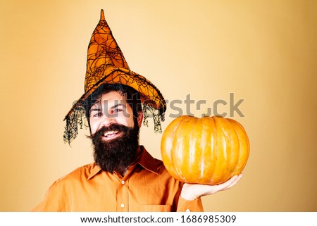 Devil man. Handsome man in Halloween hat holding pumpkin - portrait close up. Halloween Man posing with pumpkins. Design for Halloween banner. Happy Halloween Stickers