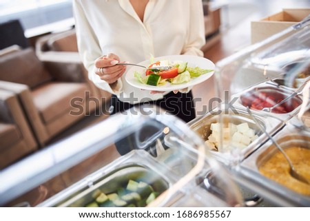 Close up of female hands holding plate with fresh vegetable salad and spoon stock photo