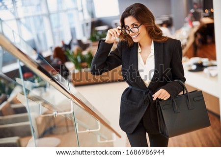 Attractive lady with elegant bag standing on stairs stock photo