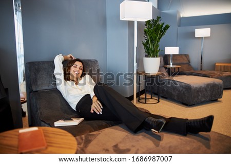 Beautiful smiling lady lying on comfortable daybed stock photo