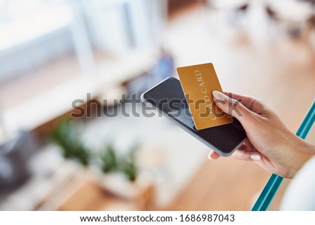 Close up of female hand with cellphone and credit card stock photo