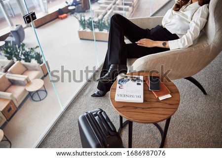 Stylish young woman resting in comfortable chair in departure lounge stock photo