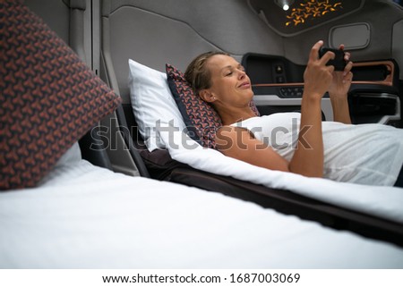 Pretty, young woman abord a first class commercial flight using their cell phone during flight