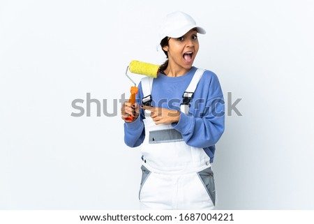 Painter woman over isolated white background surprised and pointing side