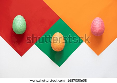 Colourful Easter eggs on coloured paper isolated on white background
