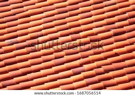 Elevated view of classic red tile clay roof with a few cracked tiles