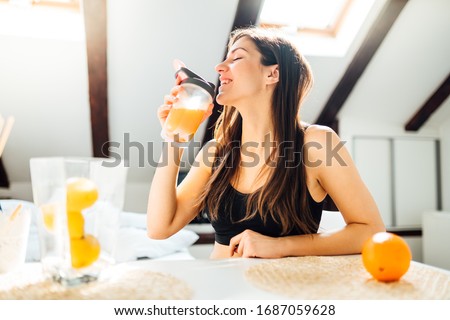 Woman at home drinking orange flavored amino acid vitamin powder.Keto supplement.After exercise liquid meal.Weight loss fitness nutrition diet.Immune system support.Organic citrus fruit.Strong body Royalty-Free Stock Photo #1687059628