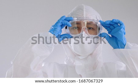 Asian doctor in protective hazmat PPE suit wearing face mask and eyeglasses Royalty-Free Stock Photo #1687067329