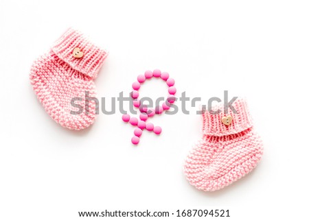 Pink booties for girl - pregnancy concept with Venus sign - on white background top-down