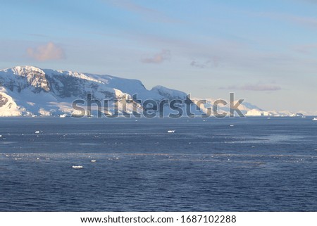 Icebergs and mountains. Sunset lights in the coast of the Antarctic Peninsula, Danco Coast, Antarctica