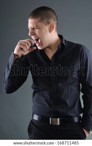 Angry businessman biting a mobile phone