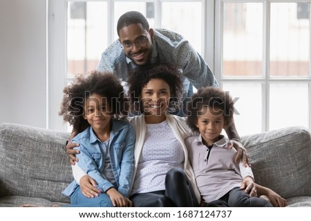 Mixed race African ethnicity full family gathered together in living room photo shooting look at camera, happy family portrait, first new home, loan and mortgage, next generation and adoption concept