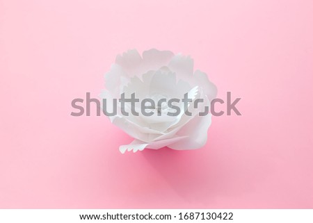 Handmade paper art and cut white flower on pink background. 