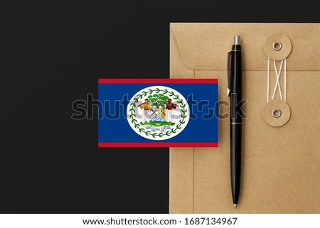 Belize flag on craft envelope letter and black pen background. National invitation concept. Invitation for education theme.