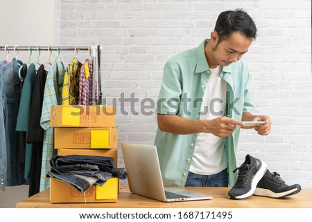 Asian man working taking photo to shoes with smart phone for post to sell online on the internet, Start up small business owner work at home office