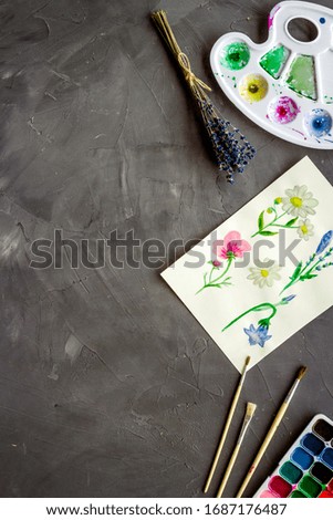 Watercolor painting. Picture with flowers, paints, palette on grey background top-down copy space