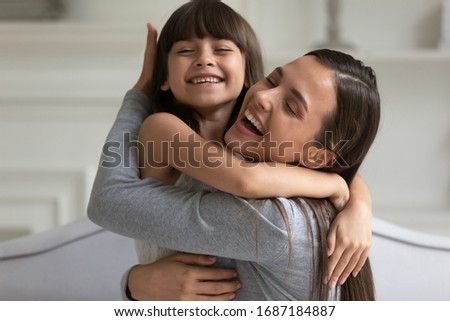 Happy young mother and cute little preschooler daughter hug and cuddle showing love and care, smiling small girl child embrace overjoyed mom enjoy family time weekend together, bonding concept Royalty-Free Stock Photo #1687184887