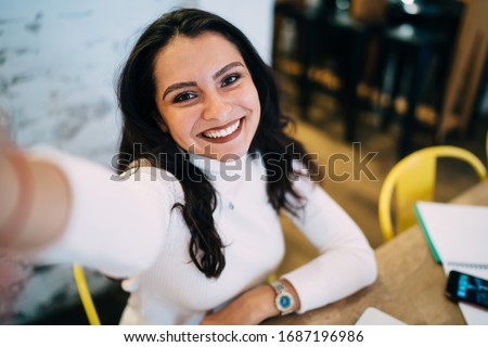 Close up selfie portrait of cheerful hipster girl with perfect toothy smile on face,happy Caucasian millennial woman with brunette hair laughing at camera during leisure for creating influence content