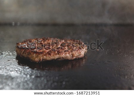 Chopped burger cutlet of minced meat and is fried with smoke on an electric stove.