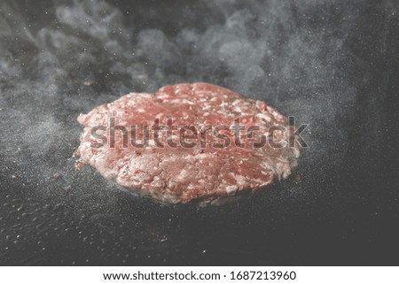 Chopped burger cutlet of minced meat and is fried with smoke on an electric stove.