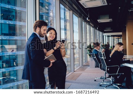 Successful woman formally dressed showing video about financial job during communication with male partner, diverse colleagues connecting to office wifi on modern technology reading trade news